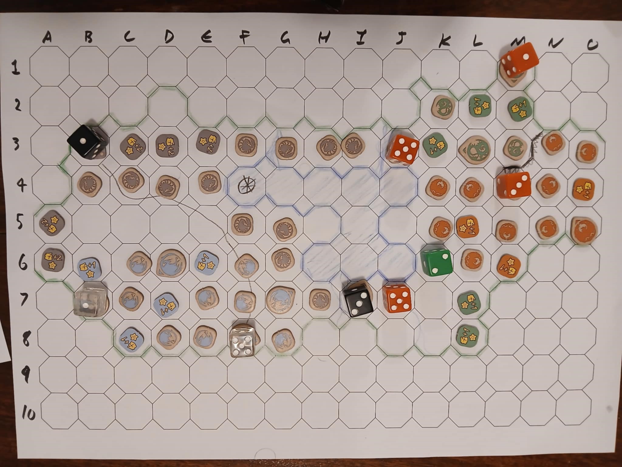 A board from above with pieces from various games. Terrain of a valley with a lake in the middle